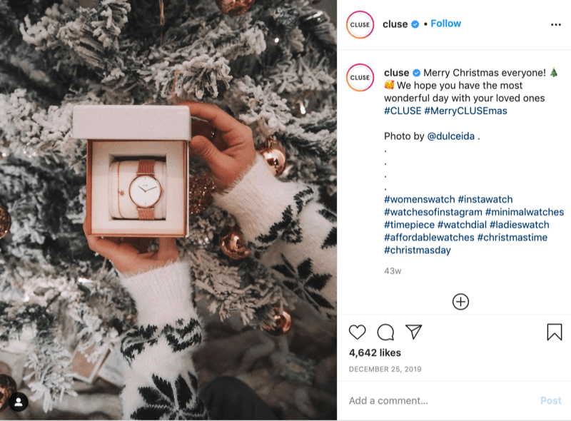 príspevok na instagrame od @cluse ukazujúci obrázok modelu so snehovými vločkami, ktorý drží hodinky pred zasneženým stromom, od @dulceida s hashtagmi #cluse a #meryclusemas